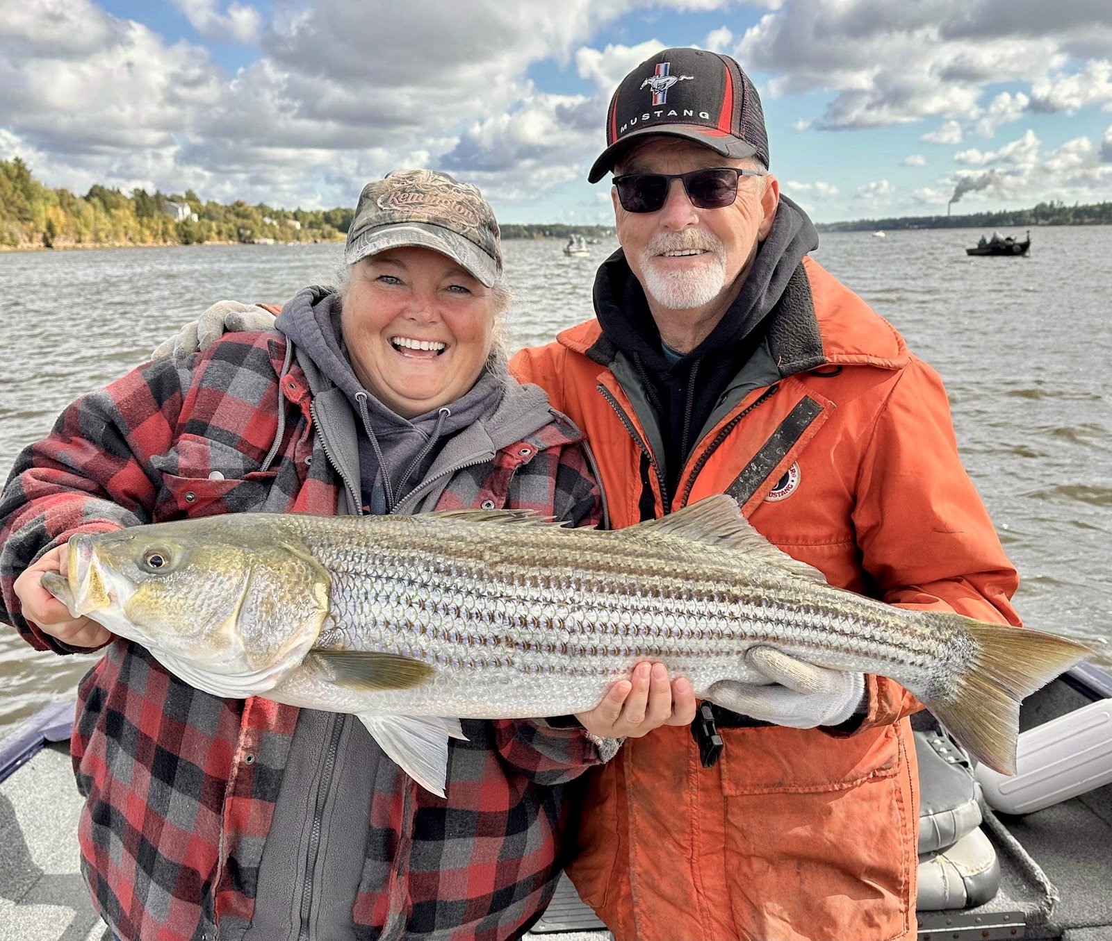 Couple holding a striped bass