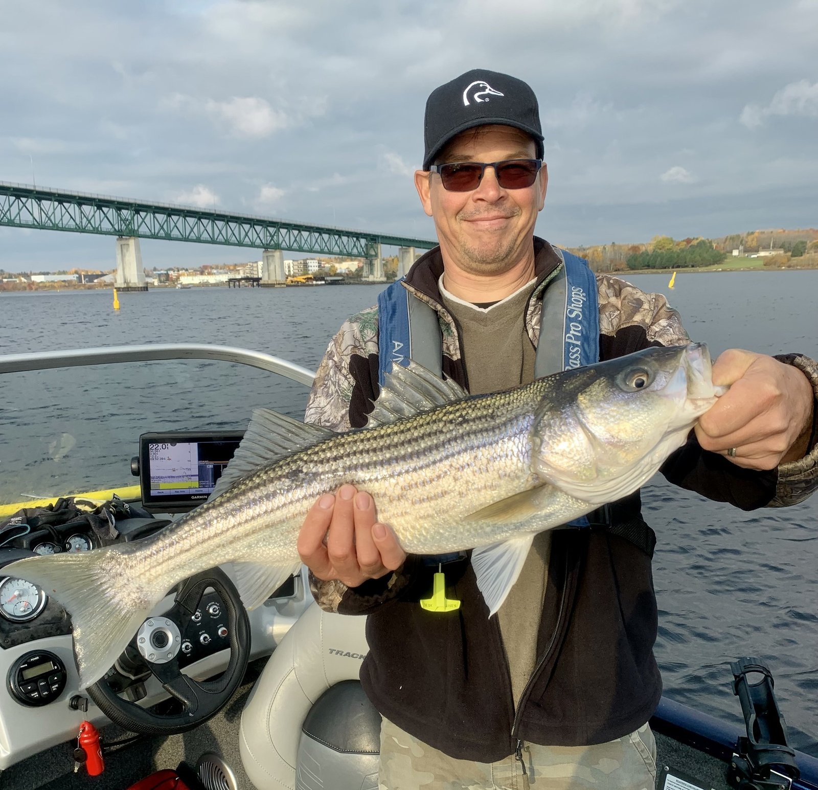 Angler with striped bass on the Miramichi River